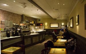 A welcoming cafe with comfortable seating, warm lighting, and a modern decor perfect for relaxing or working.