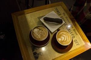 Delicious coffee drinks and chocolate pastry on a wooden table at cozy cafe setting.