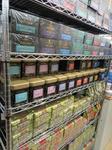 A diverse selection of scented teas displayed on metal shelves, perfect for tea enthusiasts.