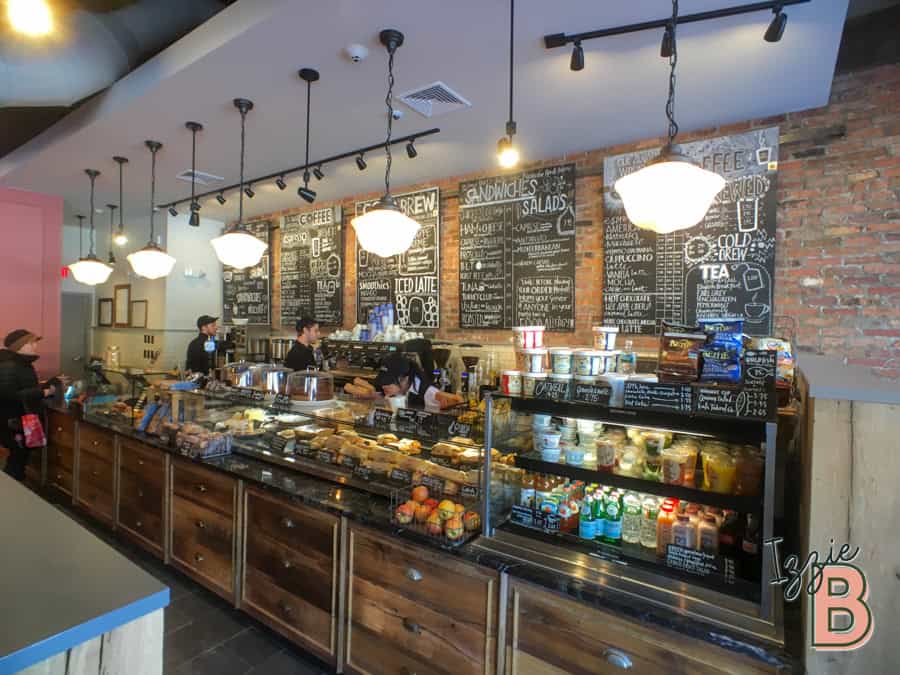 Cozy cafe with blackboards displaying coffee, tea, and snack options, featuring warm lighting.