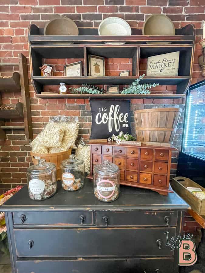 Charming coffee station setup with jars, vintage furniture, and decorative signs for cozy ambiance.