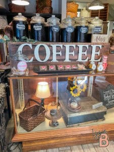Coffee display with jars of flavored coffee and baked goods.