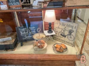 Decorative bakery display with croissants, cookies, and a cozy lamp.