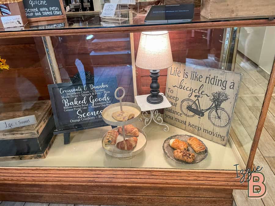Decorative bakery display with croissants, cookies, and a cozy lamp.