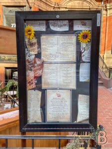 Bright outdoor menu display with colorful decorations and detailed food and drink options, perfect for visitors seeking a cozy café experience.