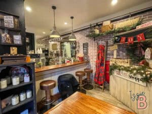 Inviting coffee shop scene featuring warm lighting, wooden furniture, and festive holiday decorations at Izzie Bytes.