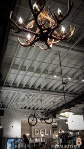 Elegant rustic chandelier with antler design, hanging lights, and vintage industrial decor.