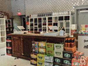 Wine shop interior with shelves of wine bottles and display boxes, showcasing various alcoholic beverages.