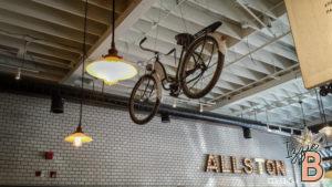 Bike hanging decor enhances industrial style in trendy cafe setting.