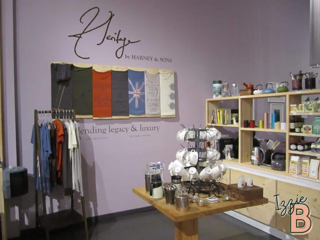 Cozy cafe with clothing and accessory displays, coffee brewing area, and elegant wall art.