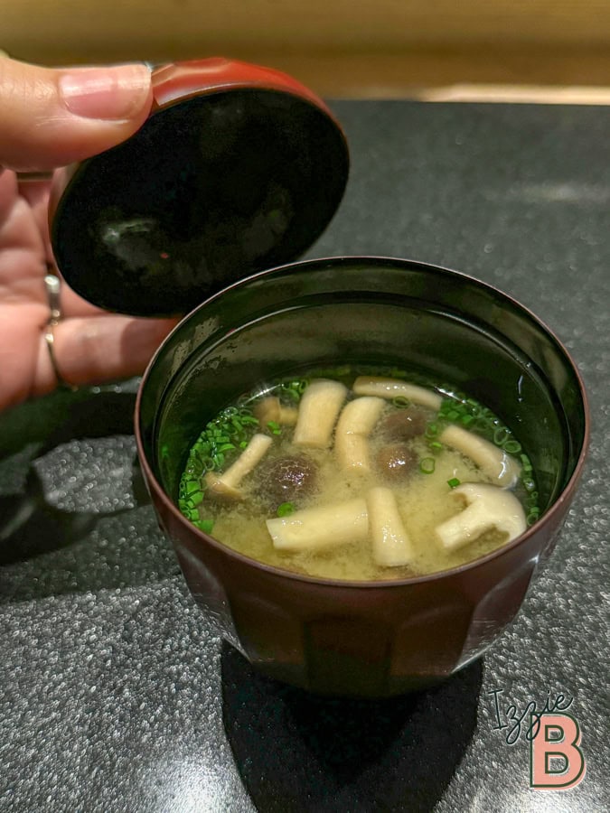 Traditional Japanese miso soup with mushrooms and green onions.