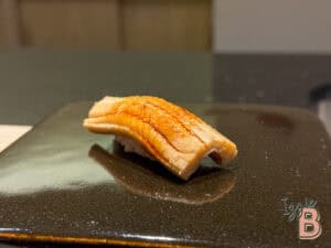 Delicious eel sushi served on a black plate, highlighting Japanese cuisine and fresh sushi ingredients.