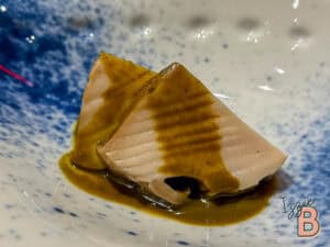 Sashimi with wasabi sauce on a blue and white plate, ideal for sushi and seafood enthusiasts.