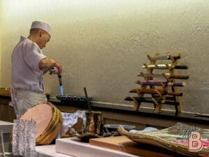 High-quality sushi chef using blowtorch to craft exquisite sushi dishes at Izzi Bytes.