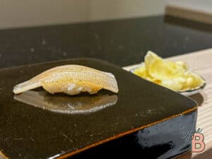 Delicious sushi slice prepared on a hot stone with wasabi and ginger on the side. Authentic Japanese cuisine served fresh.