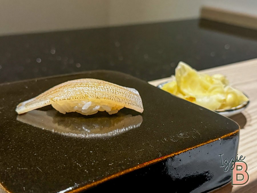 Delicious sushi slice prepared on a hot stone with wasabi and ginger on the side. Authentic Japanese cuisine served fresh.