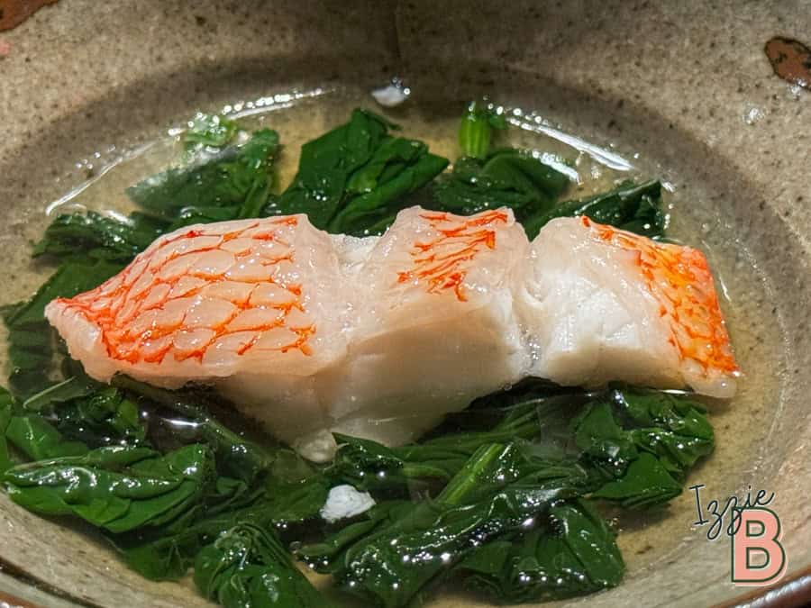 Fresh salmon cooking with vibrant spinach in a skillet.
