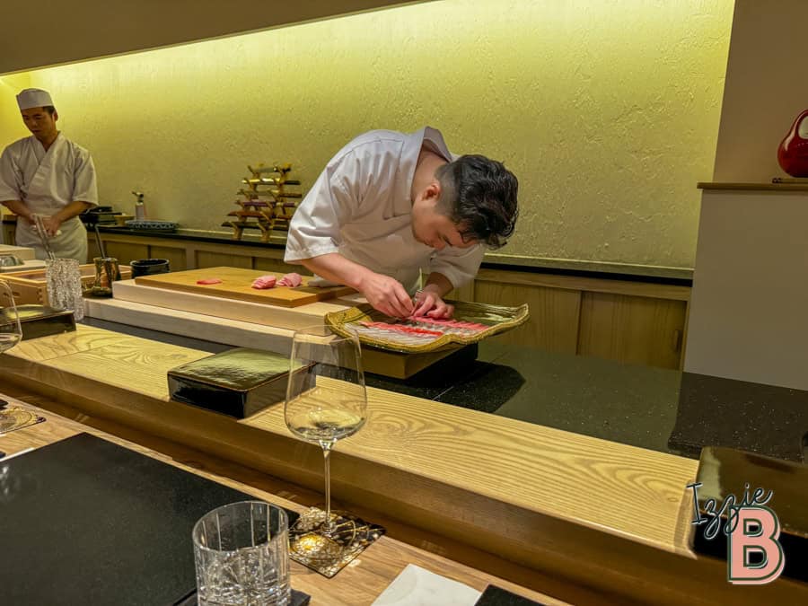 Chef preparing sushi at a high-end Japanese restaurant, showcasing skilled craftsmanship and fresh ingredients.