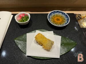 Delicious crispy tempura fish served with dipping sauce and pickled vegetables.