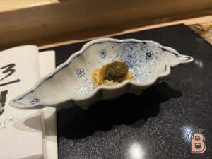 Elegant Japanese cuisine served in a handcrafted ceramic dish with a small portions of flavorful ingredients.