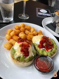 Delicious avocado egg bakes with crispy tater tots and salsa, served with ketchup on the side. Perfect brunch dish for avocado lovers.